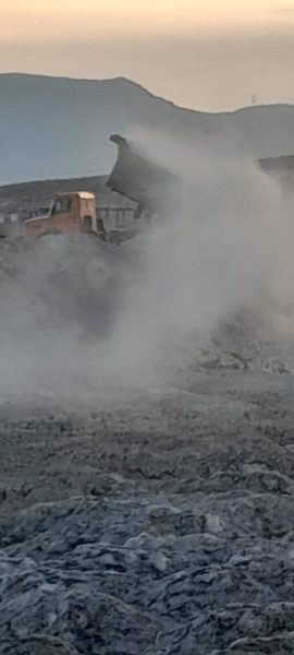 کامیون در حال تخلیه پسماند در کارخانه قند کوار و انتشار غبار شدید